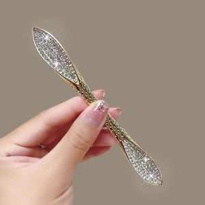 Détail macro du pic à cheveux doré serti de strass argentés brillants pour chignons