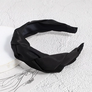 Detailed view of black woven braid headband with soft satin texture and knot design