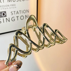 Detailed view of the wavy golden metal hair claw with a polished electroplated finish
