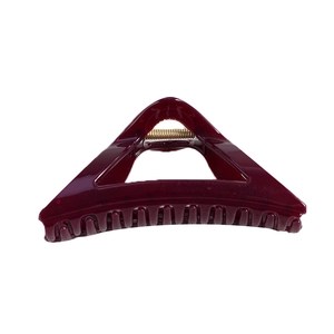 Deep red triangular matte shark hair claw clip with golden metal spring on white background