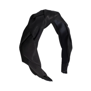 Elegant French braided headband in black satin-like fabric with a stylish top knot