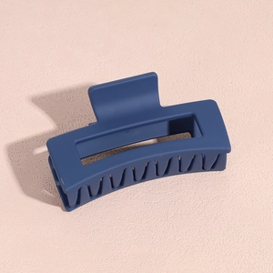 Détail de la pince à cheveux en acrylique bleu marine mat avec structure creuse