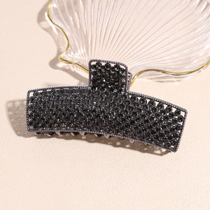 Detail of a large black metal hair claw clip with rhinestones and inner comb teeth