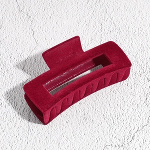 Macro shot of large burgundy flocked rectangular hair claw clip on stone surface