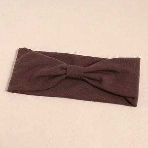 Detailed close-up of dark brown ribbed knit elastic headband with a center bow tie knot