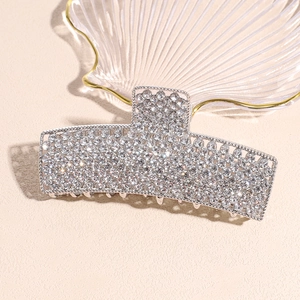 Macro shot of large silver hair claw clip with multiple rows of sparkling rhinestones