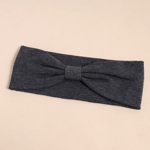 Close-up of dark grey elastic sports headband with center knot detail and soft knit texture