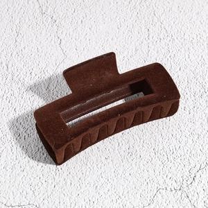 Close-up of a large dark brown flocked square hair claw clip with velvet texture finish