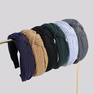 Knotted ribbed fabric headbands set in six colors on a metallic gold display stand