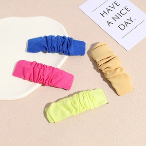 Set of four colorful pleated fabric hair clips in blue, pink, beige, and green colors