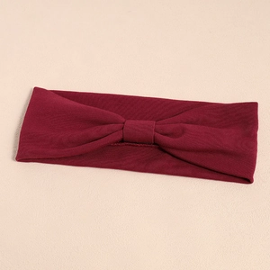 Detailed texture of burgundy ribbed fabric on a knotted elastic yoga headband