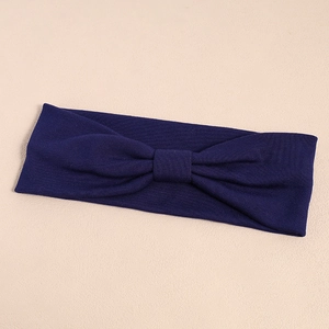Detailed macro view of dark blue elastic yoga headband with knitted texture and bow knot