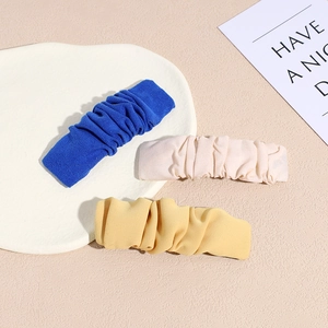 Three-piece pleated fabric hair clip set in royal blue, cream white and mustard yellow colors