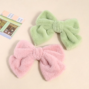 Plush bow hair clip set in soft mint green and pink faux fur for winter hair styling