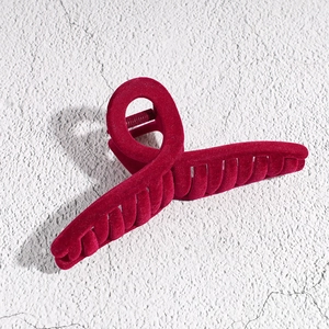 Close-up of red velvet hair claw clip with large square design and cross knot texture