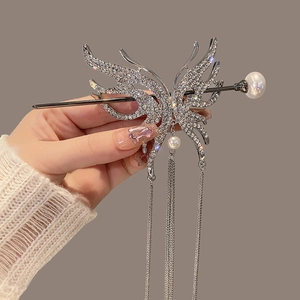 Detailed view of silver butterfly hair pin with sparkling rhinestones and pearl tassels