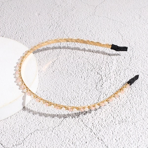 Detail van de gouden haarband met roze kristallen en witte parels voor vrouwen