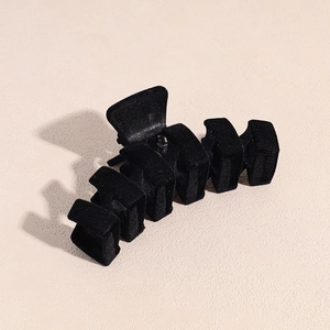 Detail view of large square black flocked hair claw clip with matte velvet texture
