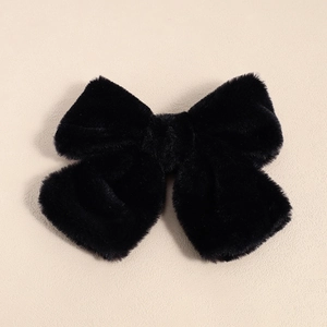 Detailed view of the soft black plush bow hair clip with luxury faux fur texture