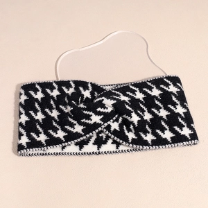 Detail of knitted houndstooth headband showing the crisscross knot and elastic strap