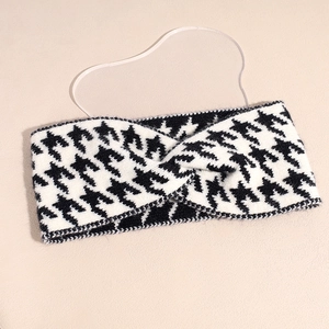 Close-up of knit houndstooth pattern and twisted cross detail on a wide winter headband