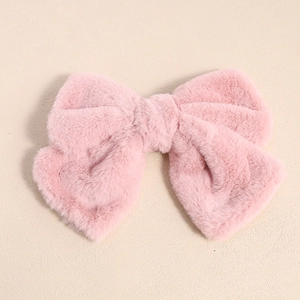Detail view of the soft pink plush bow hair clip with fluffy faux fur texture