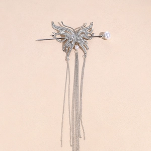 Close-up of silver butterfly hair pin with rhinestones, metal tassels and pearls