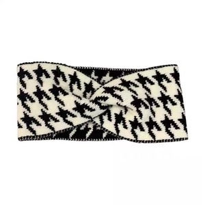 Classic black and white houndstooth knit headband with a central twist knot design