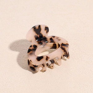 Close-up of small leopard print acetate hair claw clip with tortoise pattern detail
