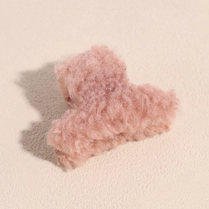 Détail de la pince à cheveux en fausse fourrure rose poudré doux pour l'automne et l'hiver