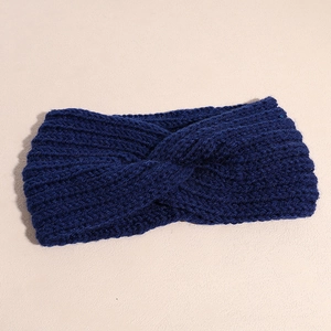Detailed texture of dark blue knitted headband featuring a stylish cross-knot design