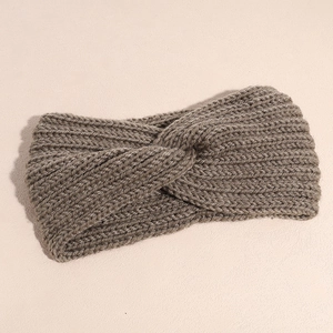 Close-up of dark taupe ribbed knit headband with cross knot detail for winter warmth