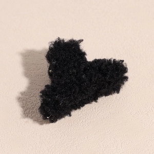 Détail d'une pince à cheveux en peluche noire en forme de cœur pour l'automne hiver