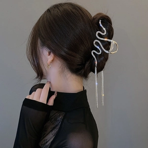 Vista dettagliata della pinza per capelli a serpente argento con strass e lunghe nappe