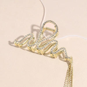 Elegante molletta per capelli in metallo dorato con onde e nappe di strass brillanti