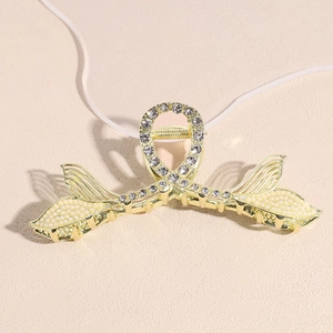 Detailed view of golden mermaid tail hair claw with sparkling rhinestones and white pearls