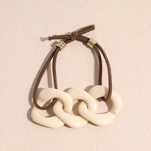 Close-up of elegant coffee-toned hair tie featuring creamy white acrylic chain link accents