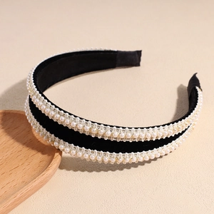 Détail d'un serre-tête en velours noir à double rangée de perles et accents dorés