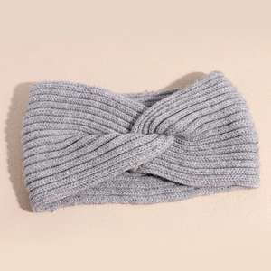 Close-up of light grey knitted headband with stylish twist knot and ribbed texture