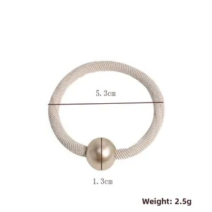 Detail of high-elastic beige hair tie with a 1.3cm gold bead and 5.3cm diameter