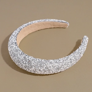 Detailed close-up of padded headband featuring silver crystals and white pearls