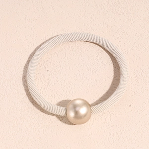 Close-up of champagne pearl ornament on elastic cream ribbed hair tie for women