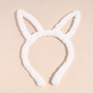 Gros plan du serre-tête oreilles de lapin en peluche blanche sur fond beige