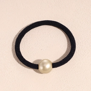 Close-up of black elastic hair tie with a single large golden pearl bead decoration