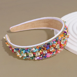 Detail of beaded headband with colorful rhinestones and turquoise on beige background