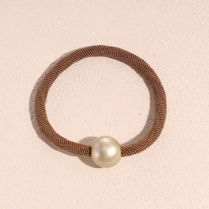 Detailed view of high elasticity brown hair tie with a champagne gold pearl ornament