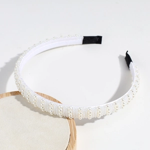 Détail d'un serre-tête tissé de perles blanches et tubes avec embouts antidérapants