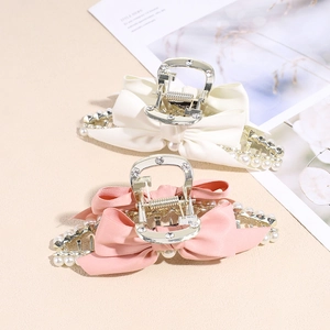 Elegant bow hair claw clips with pearls and rhinestones in cream and pink finishes