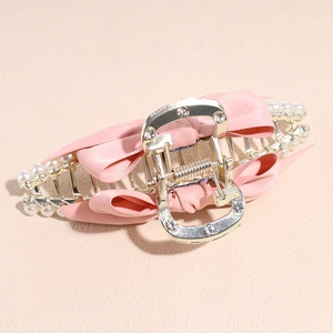 Detail of metal hair claw with pink silk bows, white pearls and sparkling rhinestones