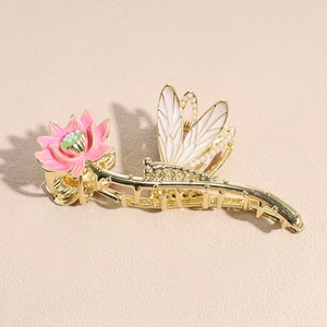 Detail van de gouden haarklem met roze lotusbloem en libelle versierd met parels